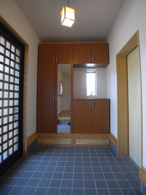 【玄関】広々していて、たっぷり収納の玄関。和風ライトが和やかな雰囲気を演出してくれます。右の扉は部屋とつながっており、帰宅してそのままアクセスできる動線になっています。