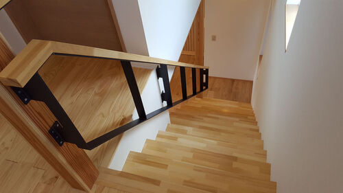 【階段】階段の鉄骨でできた手すりは木目調の柔らかく暖かい家にかっこよいアクセントに。