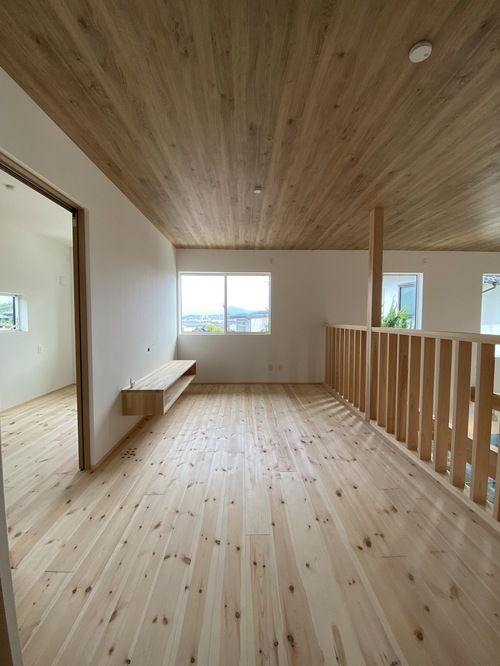【２階ホール】２階の半分以上が吹き抜けという一風変わった間取りの家ですが、高気密高断熱のおかげで２階も快適です。手すりは桧を使用しており、とてもいい香り。実は、天井はクロス貼りなんです。
